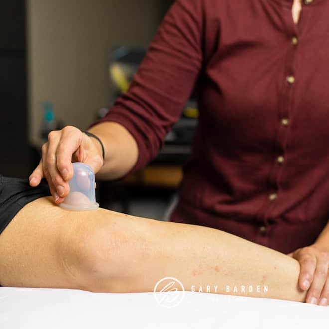 A healthcare professional performs ultrasound treatment on a patient's knee for pain relief and inflammation reduction.